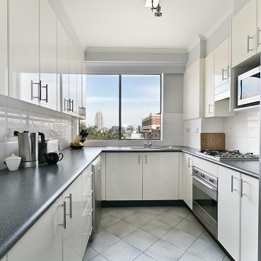 Contemporary parallel kitchen design with glossy cabinets and modern finish
